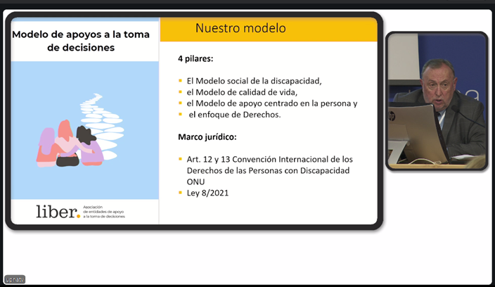 Captura de pantalla de una diapositiva de presentación titulada "Modelo de apoyos a la toma de decisiones" con texto sobre un modelo de apoyo a la discapacidad. A la derecha, un hombre habla en un podio en un vídeo superpuesto. Congreso Internacional sobre la Ley 8/2021